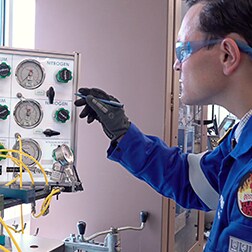 Swagelok Außendiensttechniker inspiziert das Gasverteiler-Panel in einem Labor  