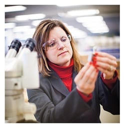 Material scientist inspecting a valve component Material scientist inspecting a valve component